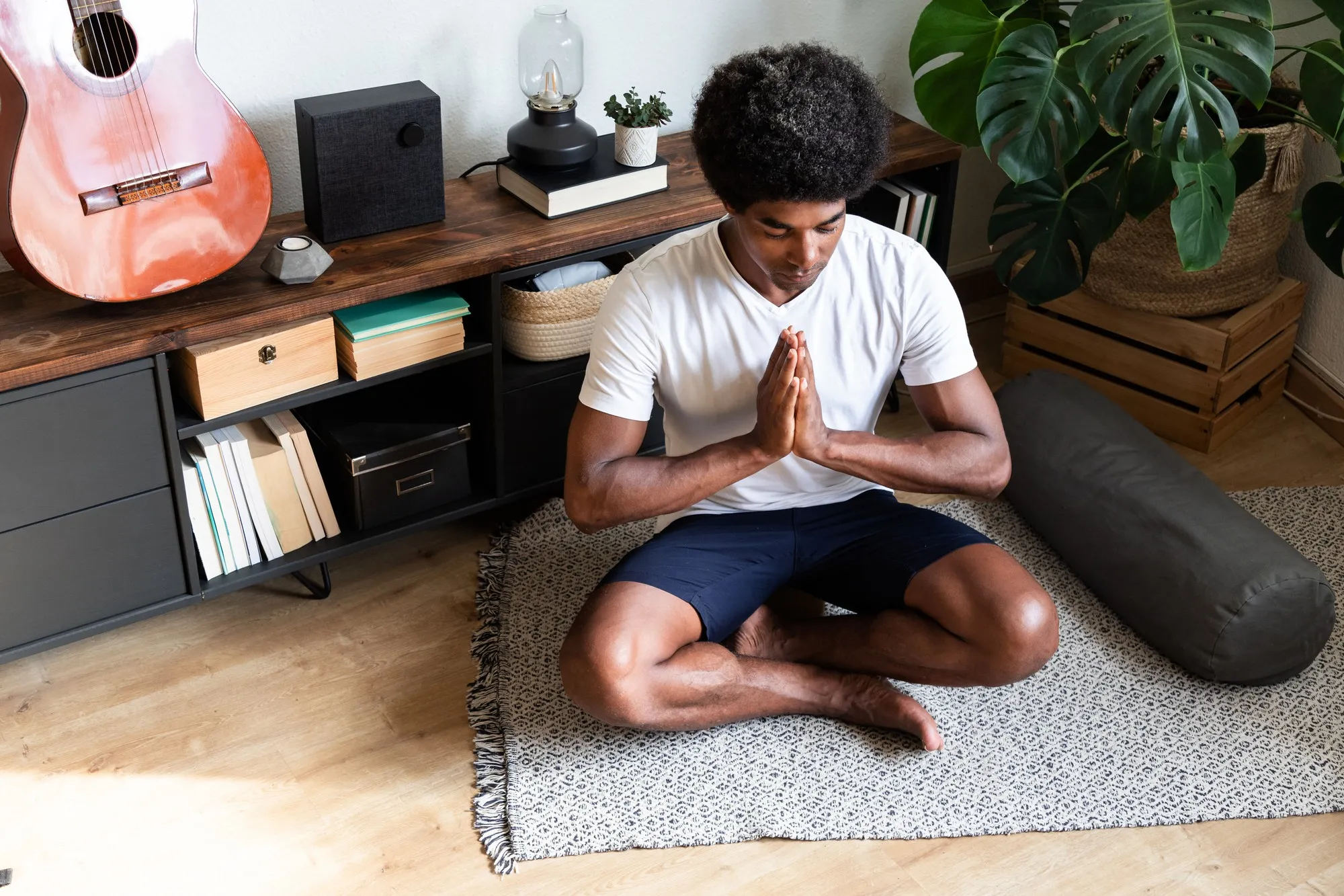 African american man meditating with hands in prayer in living room Meditation Spirituality