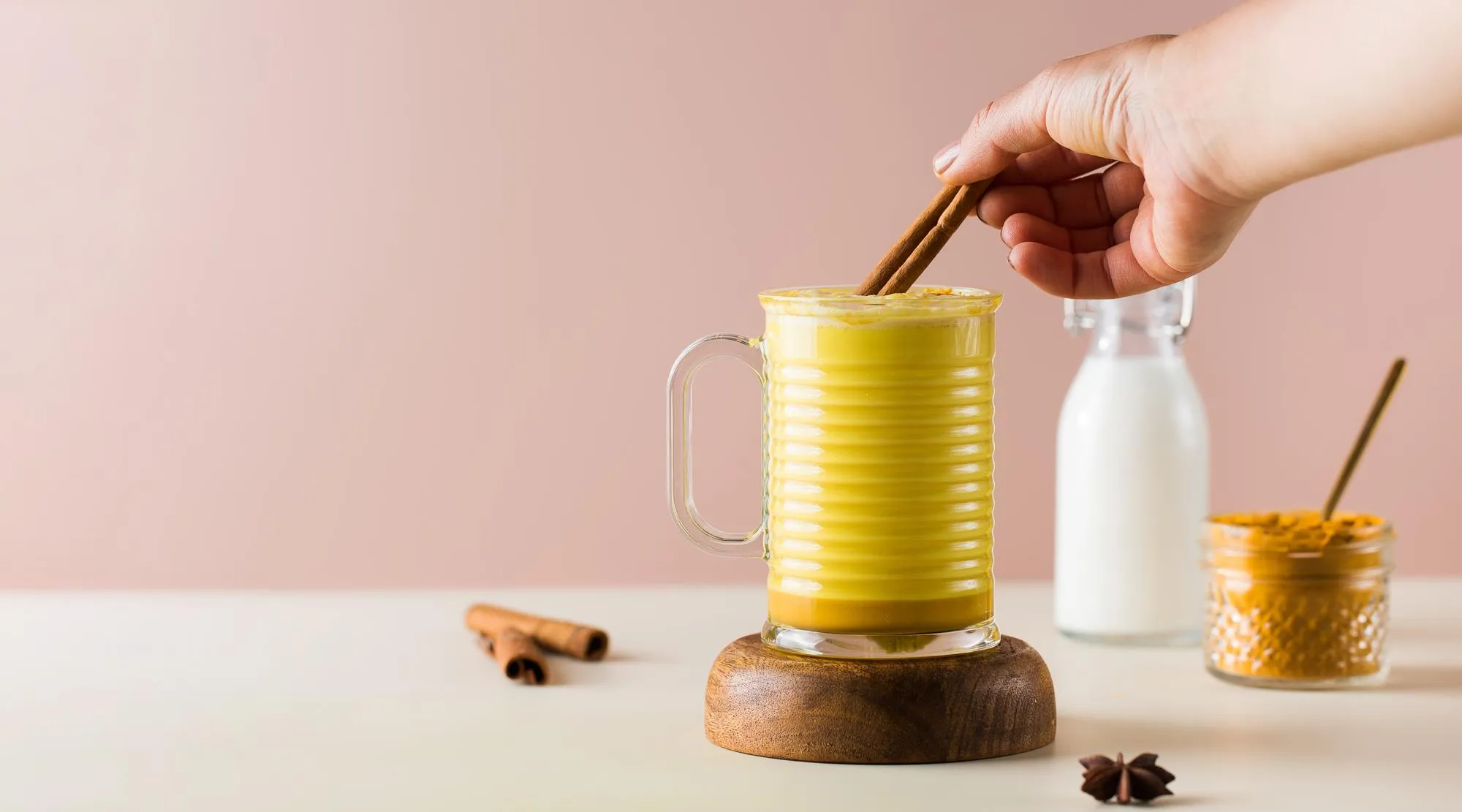 Banner with latte turmeric on a pink background moon milk for better sleep ayurvedic drink