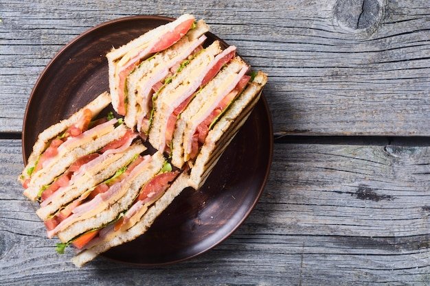 Club sandwich with bacon tomato cucumber and herbs Top view