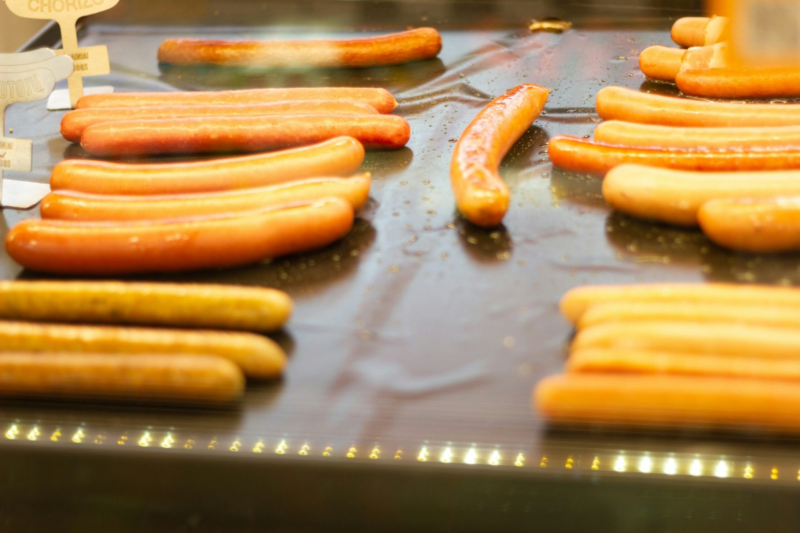 a bunch of hot dogs that are on a grill