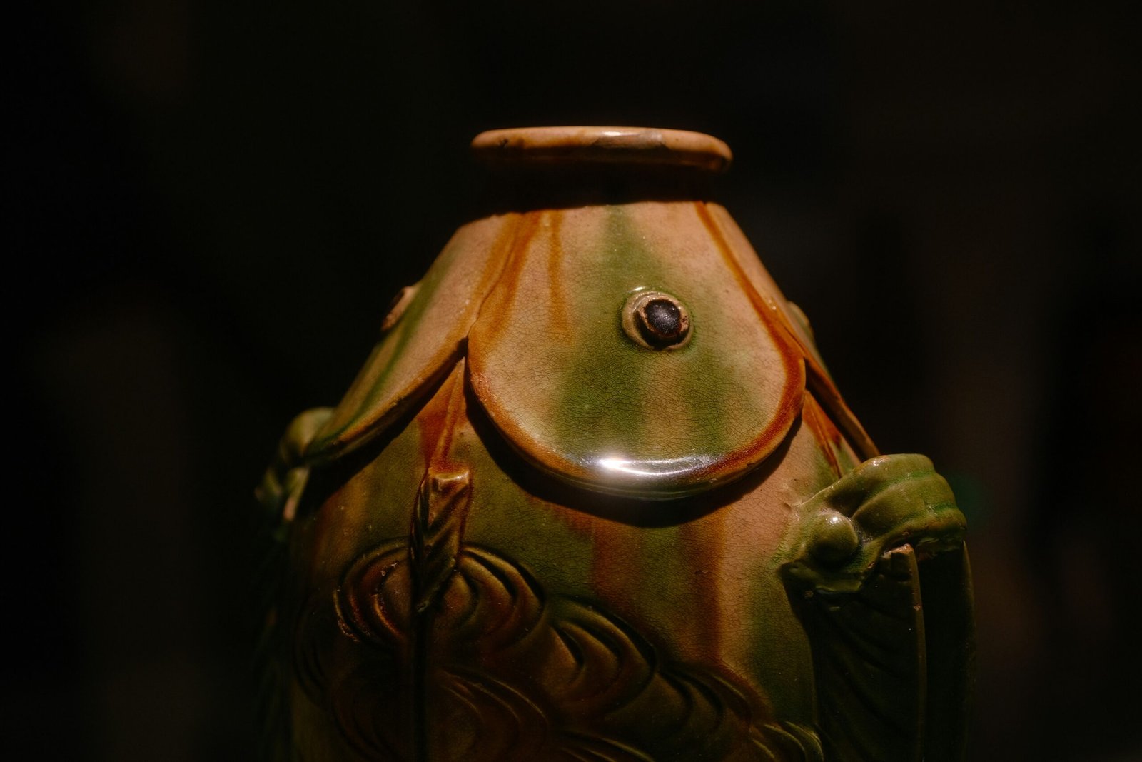 A close-up view of a colorful, old ceramic vase.