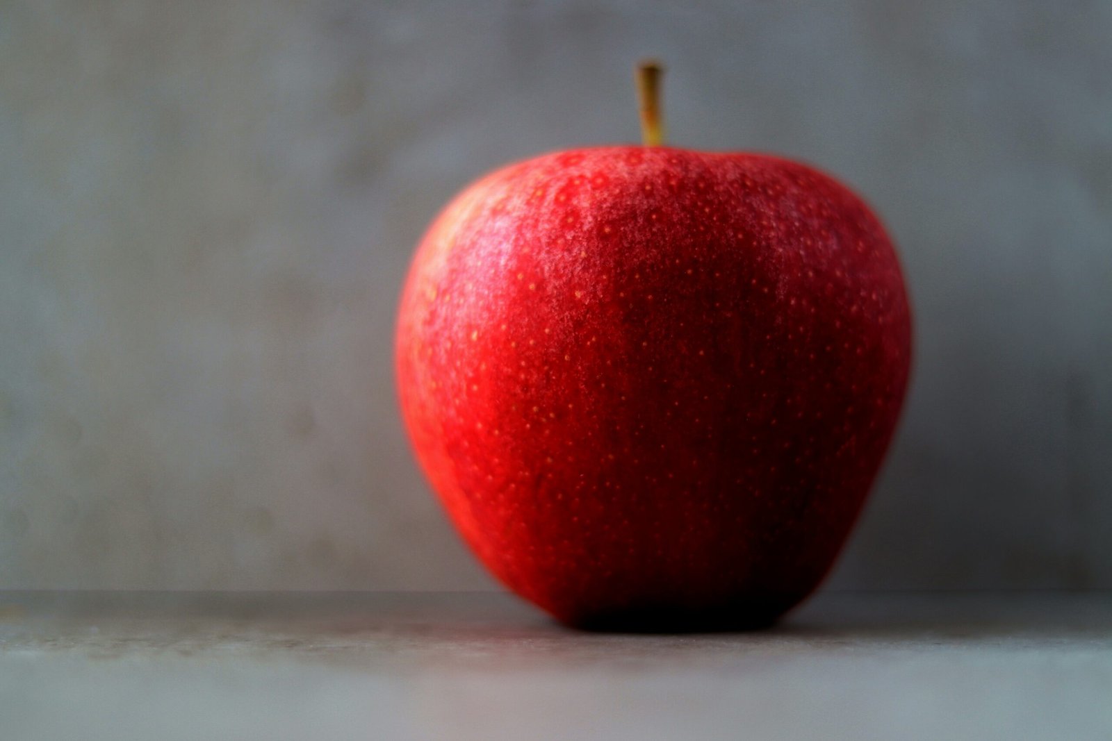 a red apple sitting on top of a table