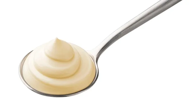 Mayonnaise in spoon isolated on white background