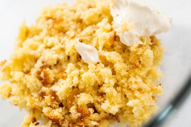 Mixing ingredients in a glass mixing bowl to prepare mermaid cakesicles.