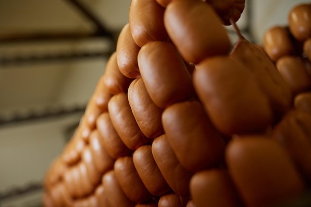 Appetizing sausages on racks in a sausage shop Sausage production
