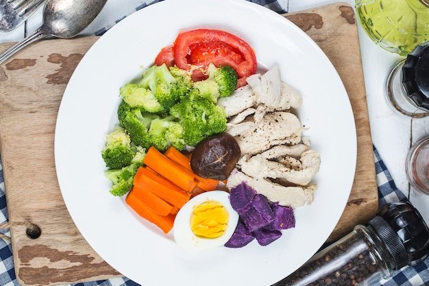 Boiled chicken breasts and vegetables with sports and diet concepts.