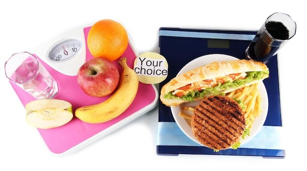 Burgers and fruit on the scales isolated on white