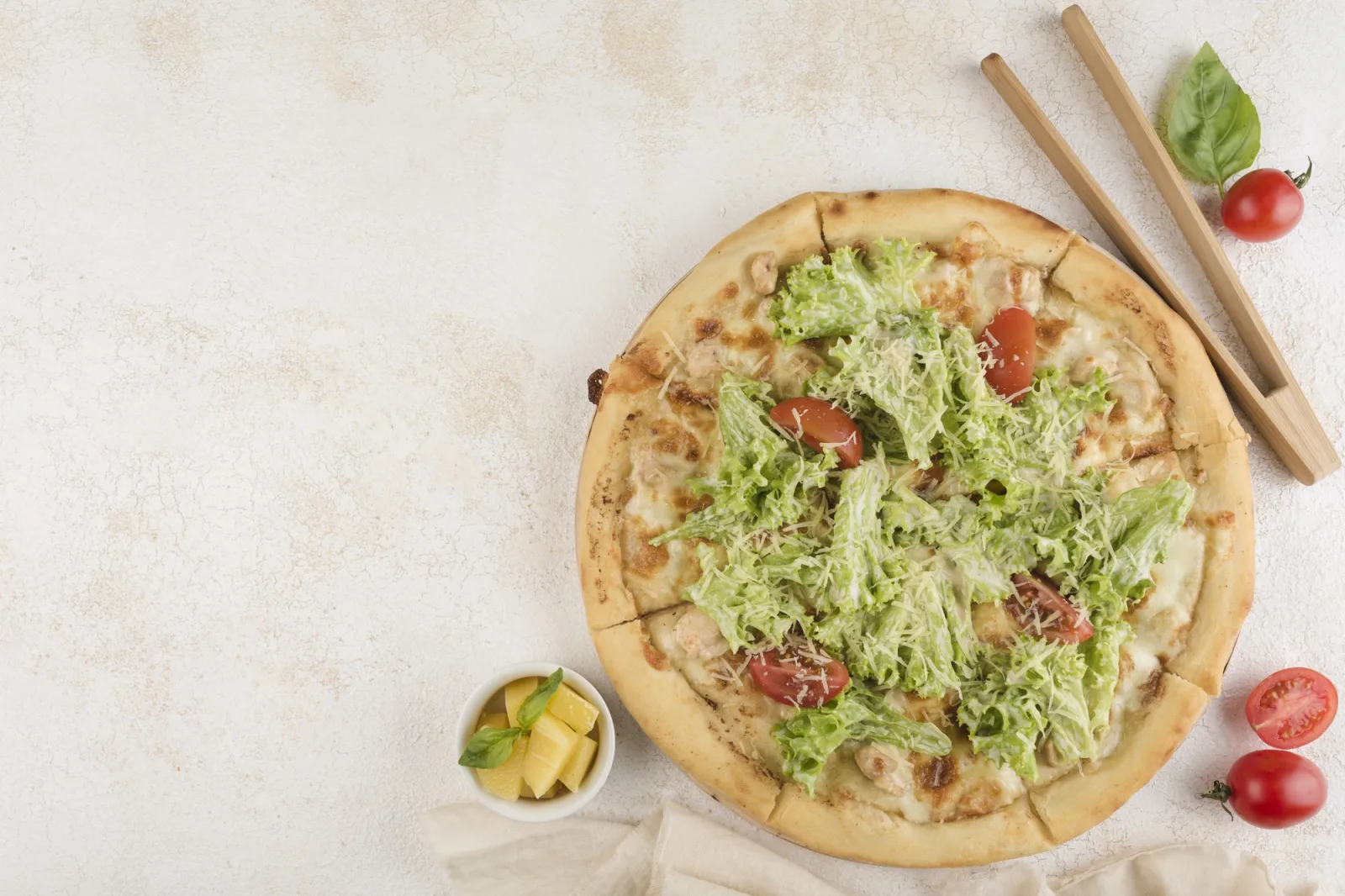 Caesar pizza with chicken fillet, tomatoes, Parmesan cheese, Mozzarella cheese, salad leaf and Caesar sauce on a light background. Top view with a copy space for the text. Classic Italian food.