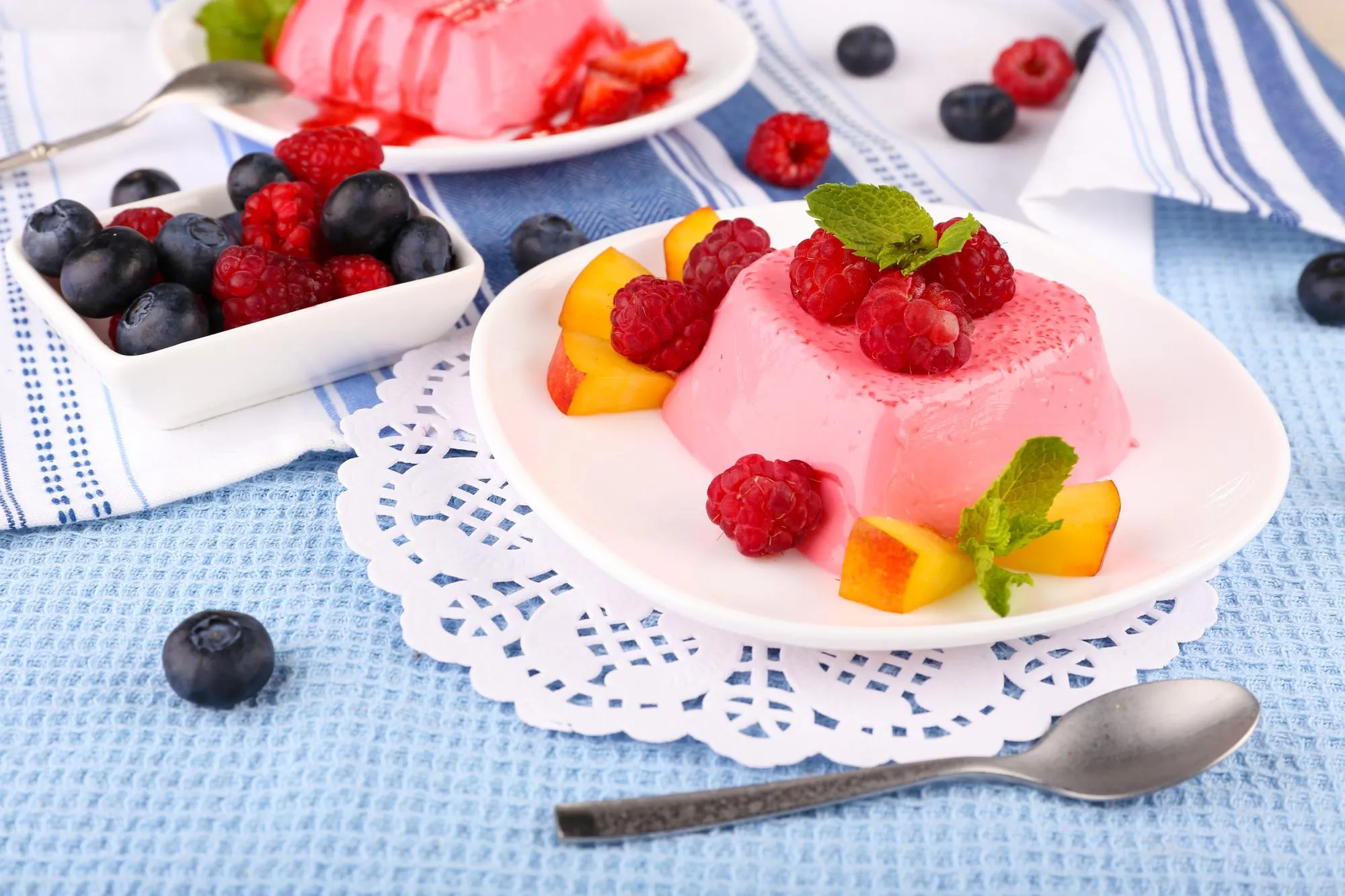 Cakes with fruit and berries on plate on lace napkin