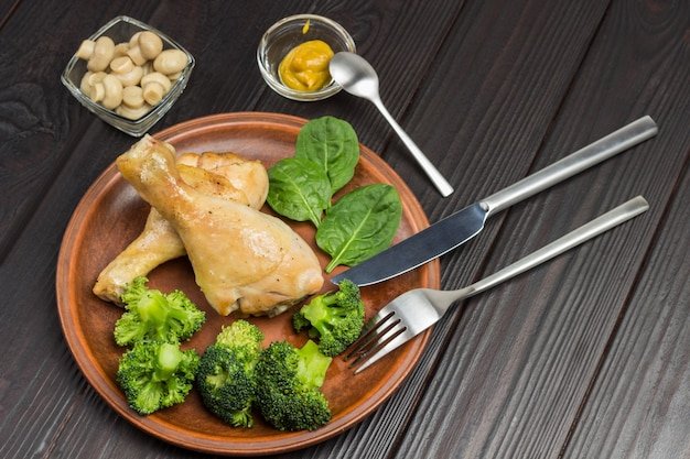 Chicken meat with broccoli and spinach on ceramic plate