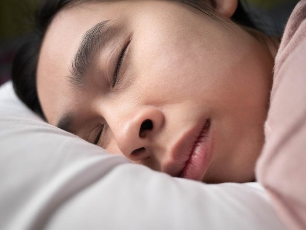 Close-up of baby sleeping on bed