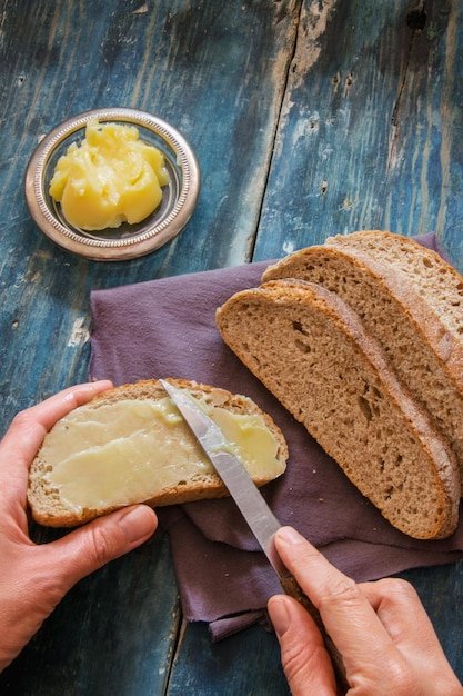 Close-up of hand holding bread on cutting board