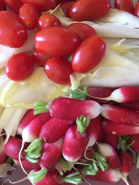 Close-up of tomatoes and cabbage with red radishes on table
