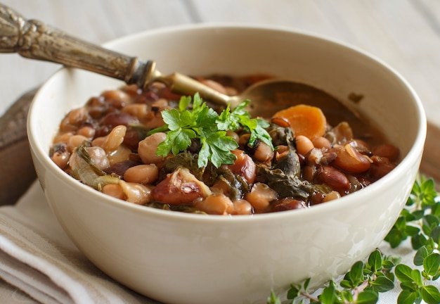 Cooked legumes and vegetables in a bowl on the old wooden table