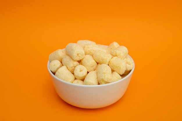 Crunchy sweet corn sticks with powdered sugar in white bowl