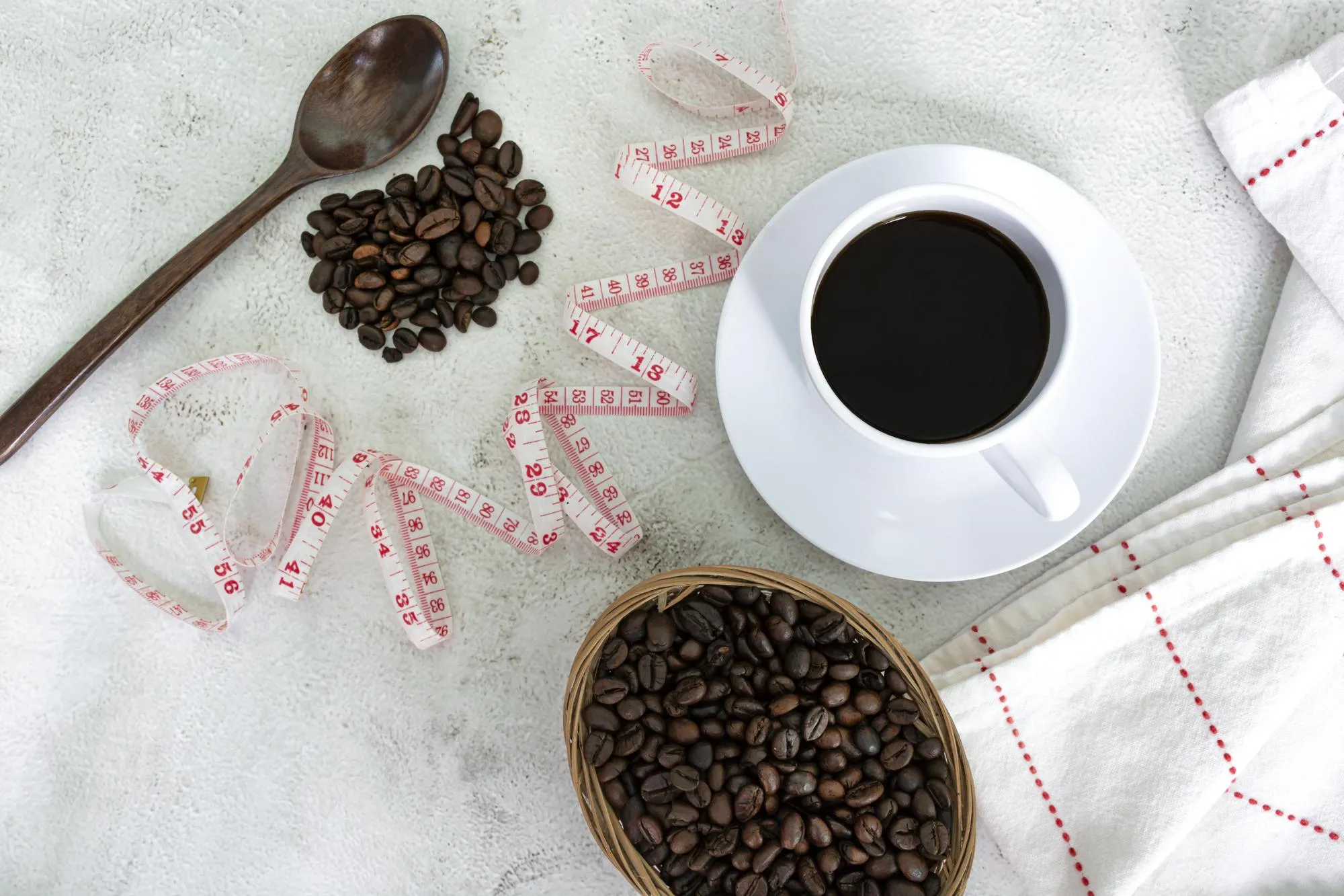 Cup of coffee and coffee beans background with measure tap on white desk Beverage and diet concept Directly above Flat lay Copy space