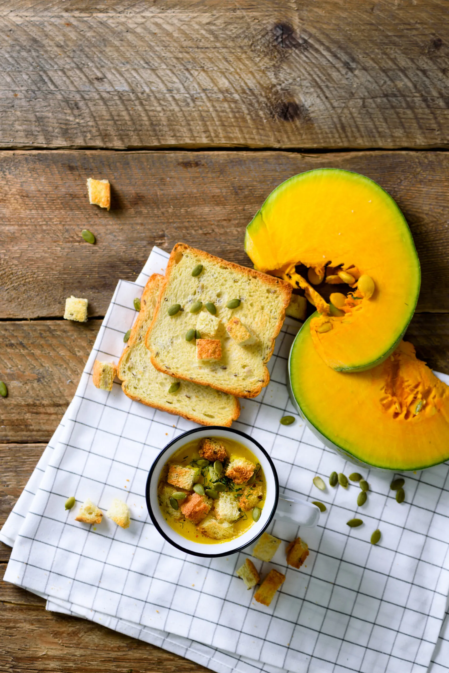 Cup of squash creamy vegetable vegetarian pumpkin carrot soup with crackers and seeds