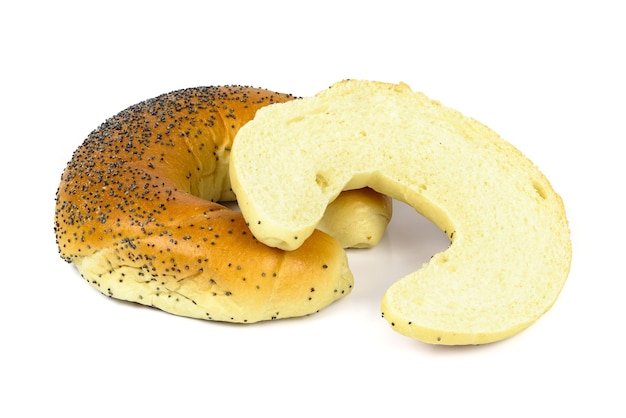 Cut crescent roll with poppy seeds on white background