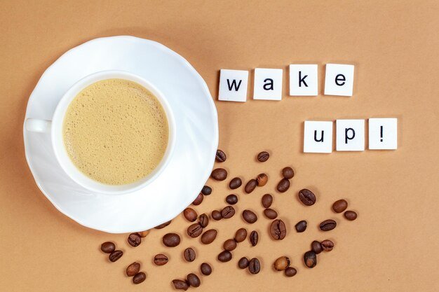 Directly above shot of empty cup by wake up text against brown background