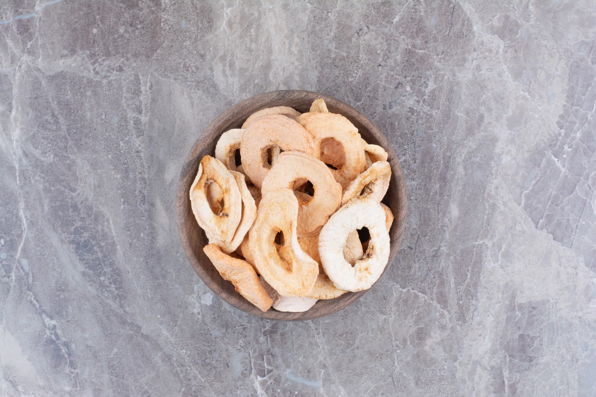 Dried healthy apples on wooden plate.