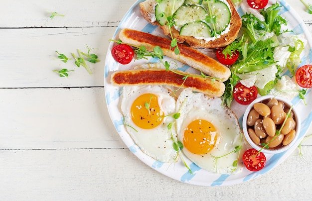 English breakfast Keto breakfast Fried egg beans chicken sausage Top view flat lay