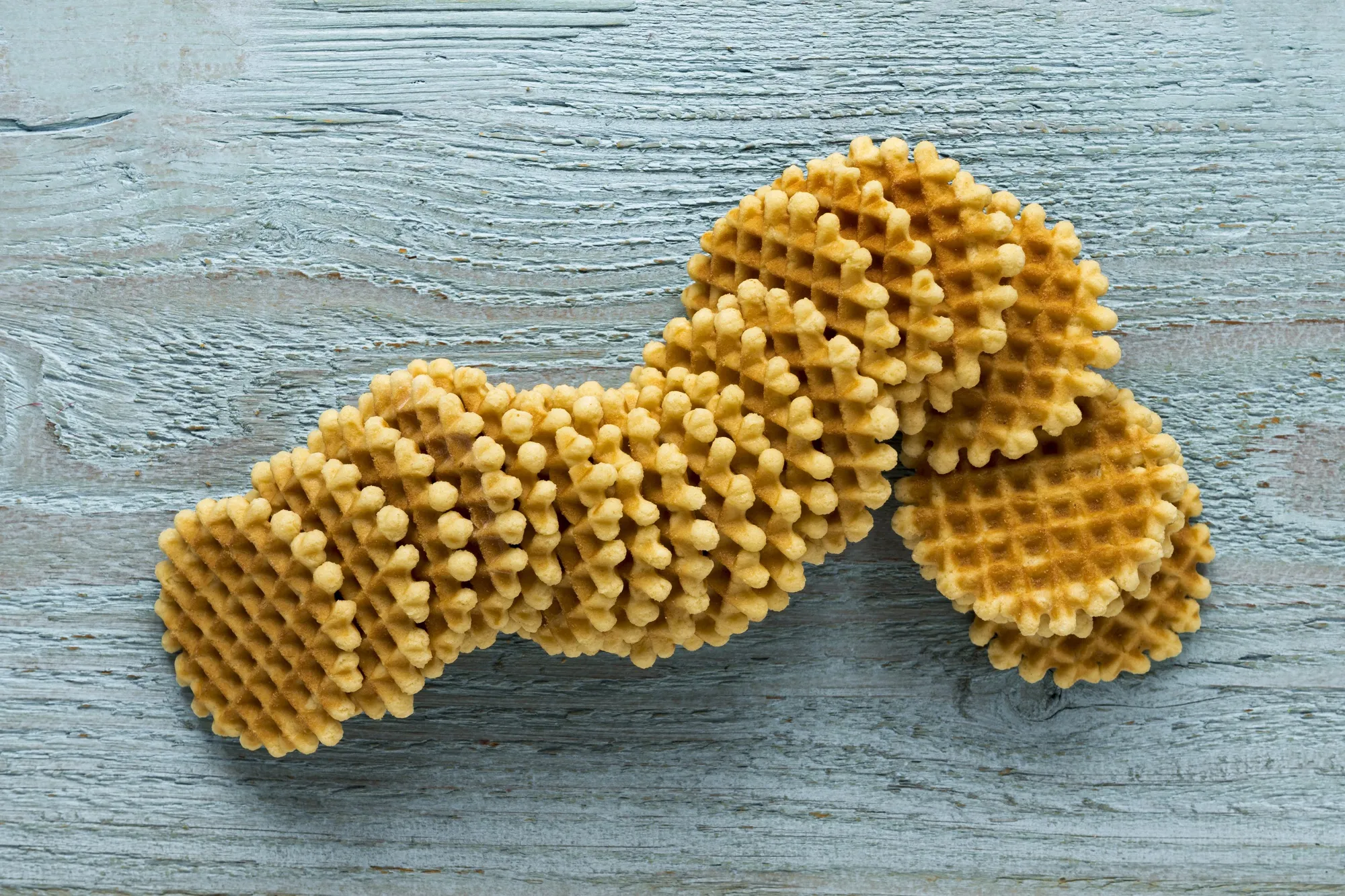 Flat lay of round waffles on wooden surface