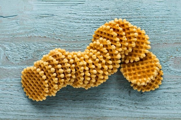 Flat lay of round waffles on wooden surface