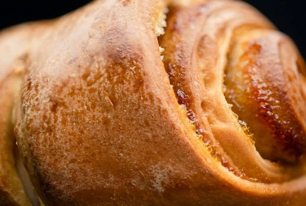 Fresh ruddy bun with jam on a black background Closeup Home bakery food cooking and pastry