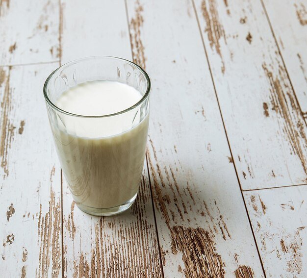 A glass of milk on the old wooden table dairy products