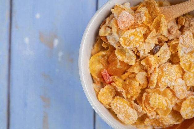 Healthy breakfast cereal oat flakes in bowl on wooden table