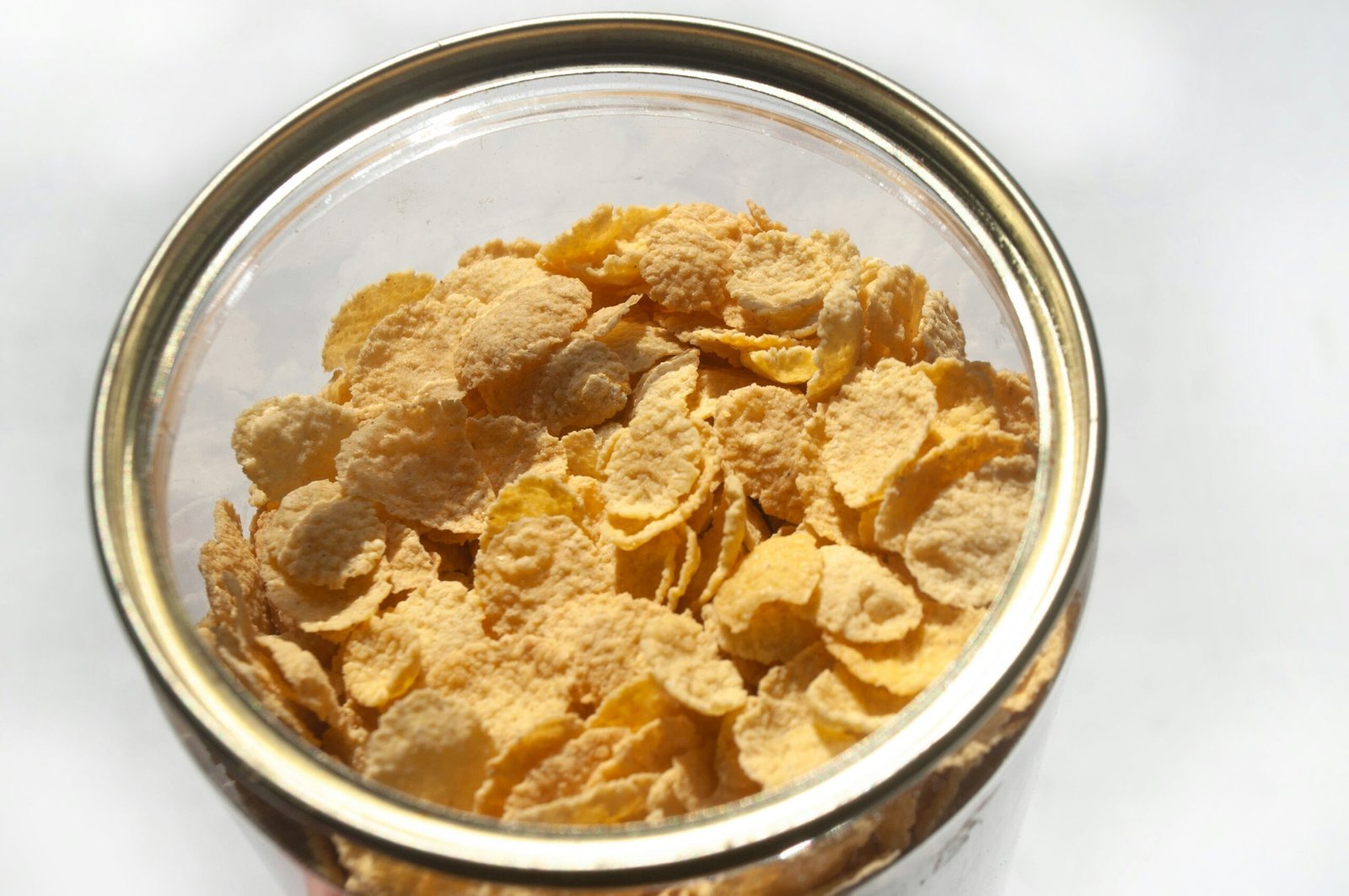 Corn flakes are in a glass jar.