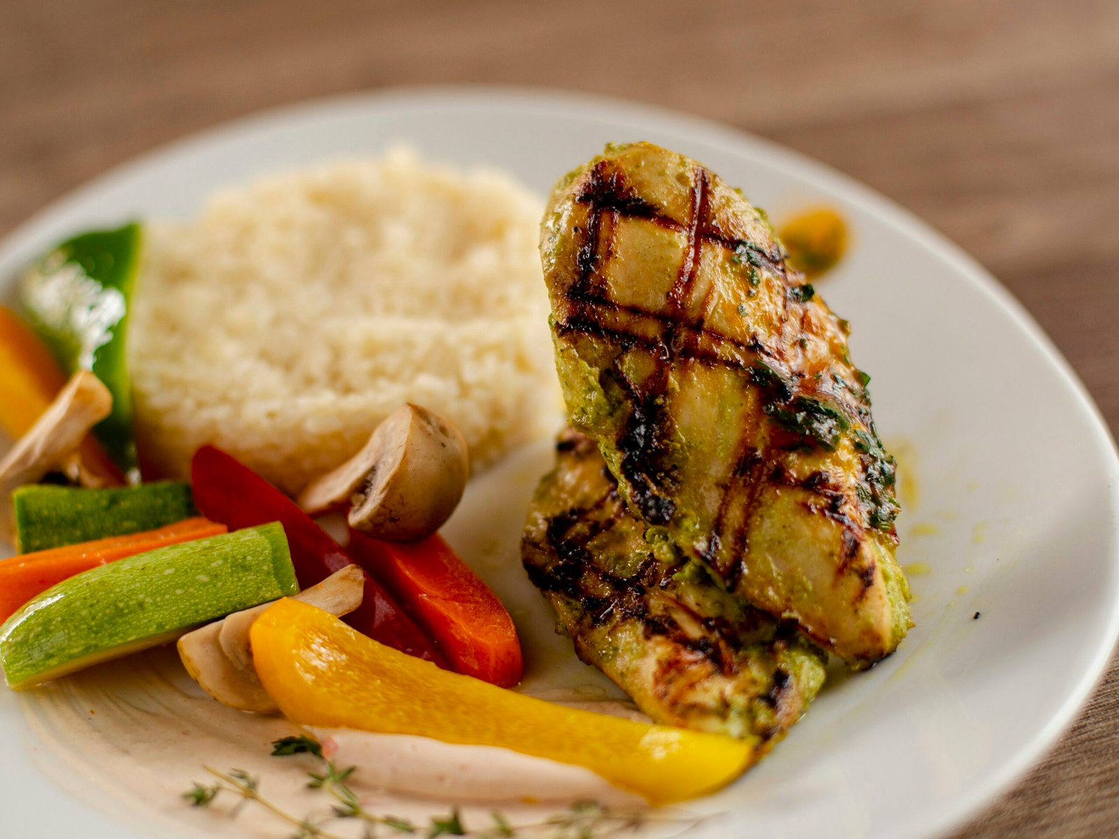 Grilled chicken breast with couscous and colorful vegetables