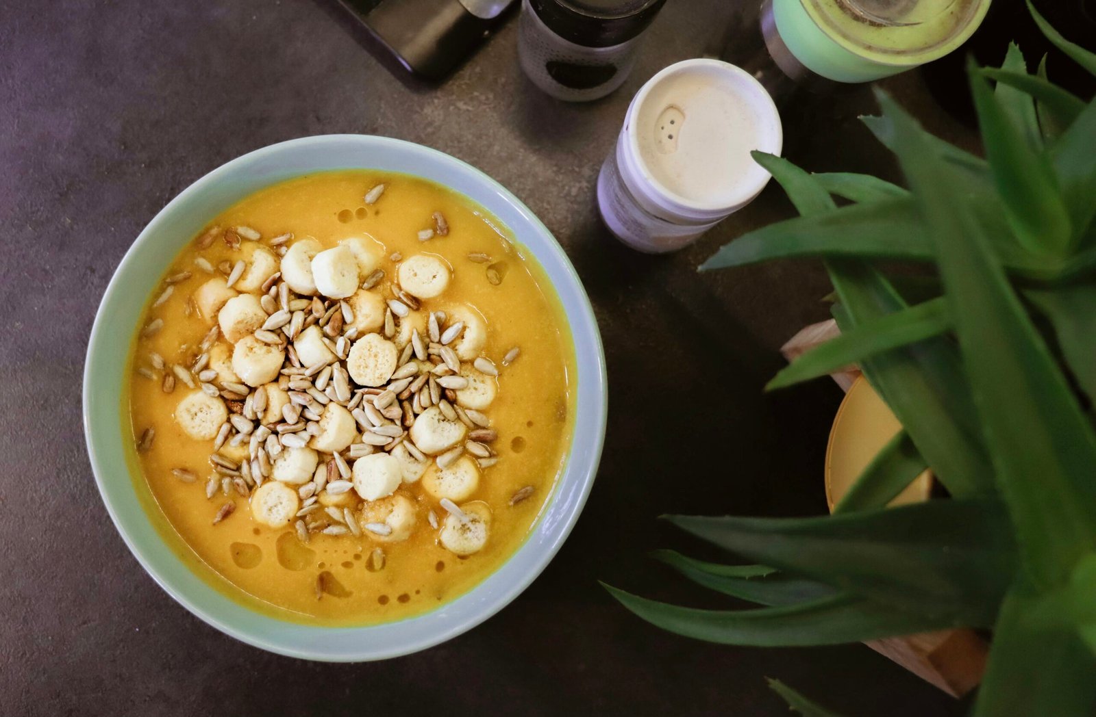 a bowl of food on a table next to a cup of coffee