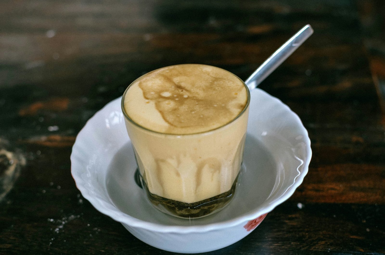 white ceramic cup with stainless steel spoon on white ceramic saucer
