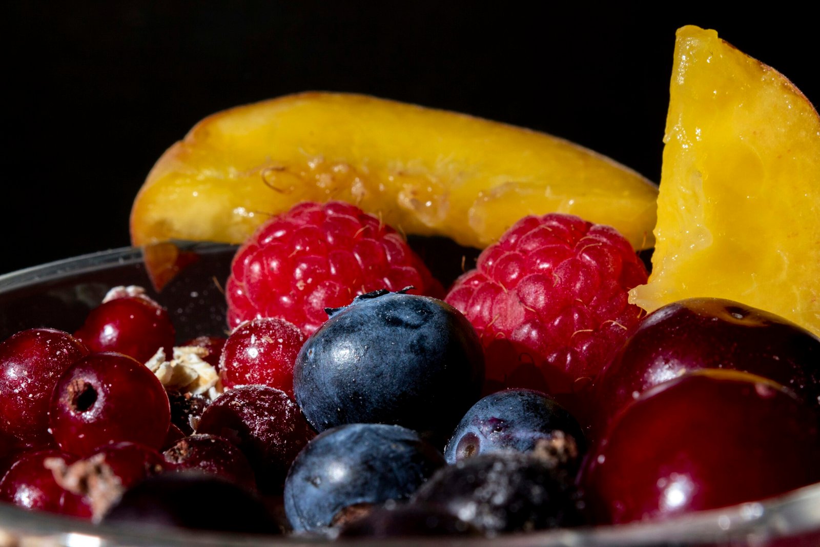 red and black berries on yellow plastic container