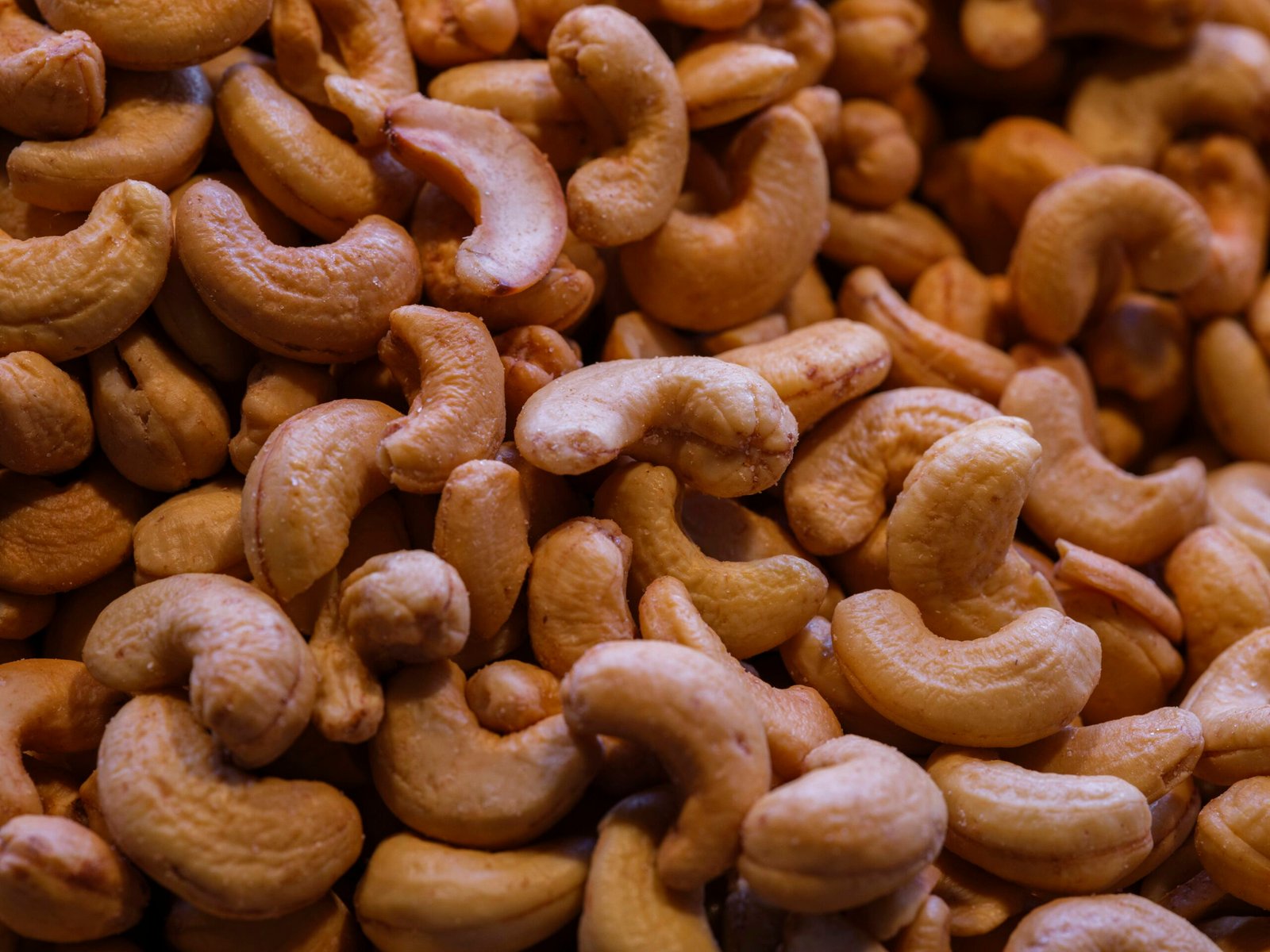 A close-up view of many roasted cashews.