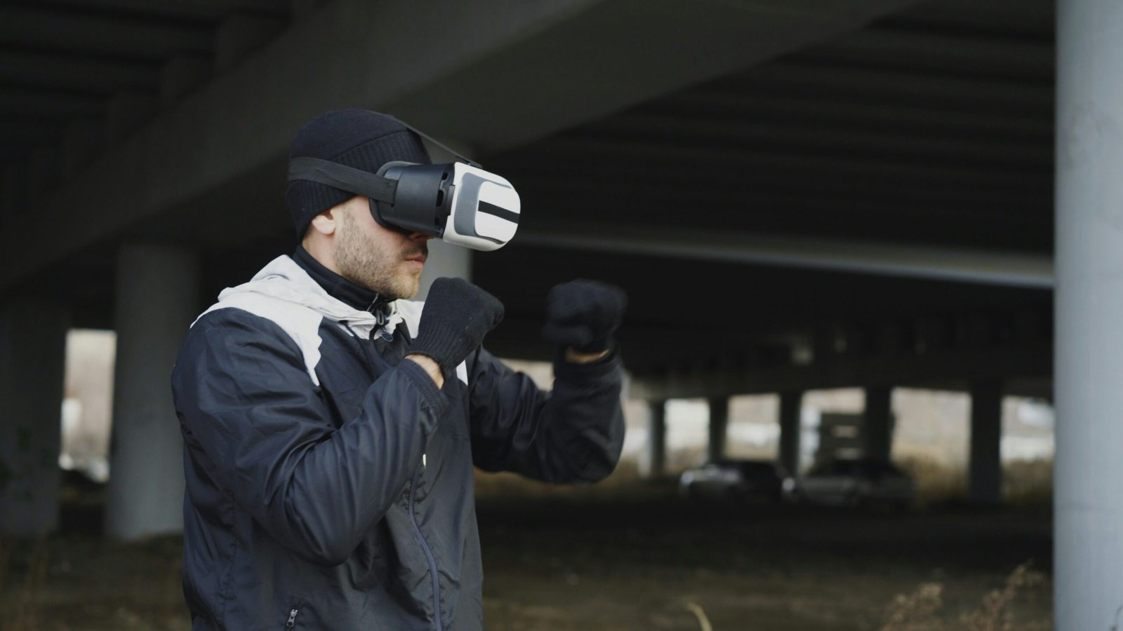 Man wearing vr headset, boxing outdoors under bridge.
