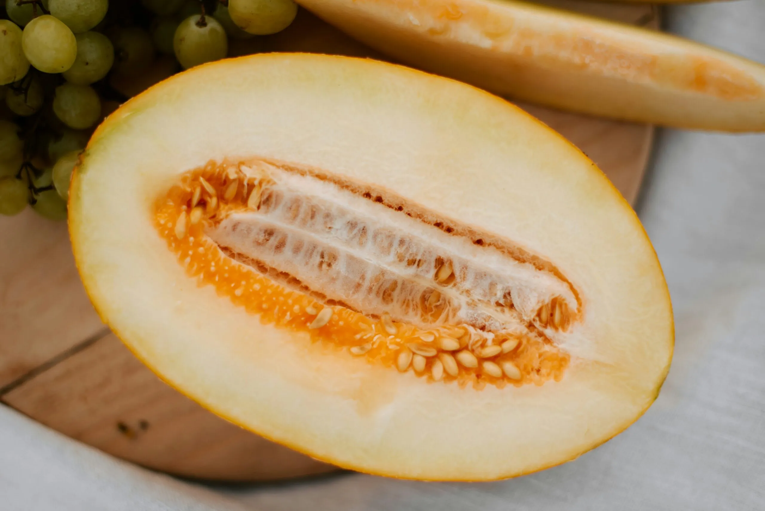 a close up of a sliced melon on a cutting board