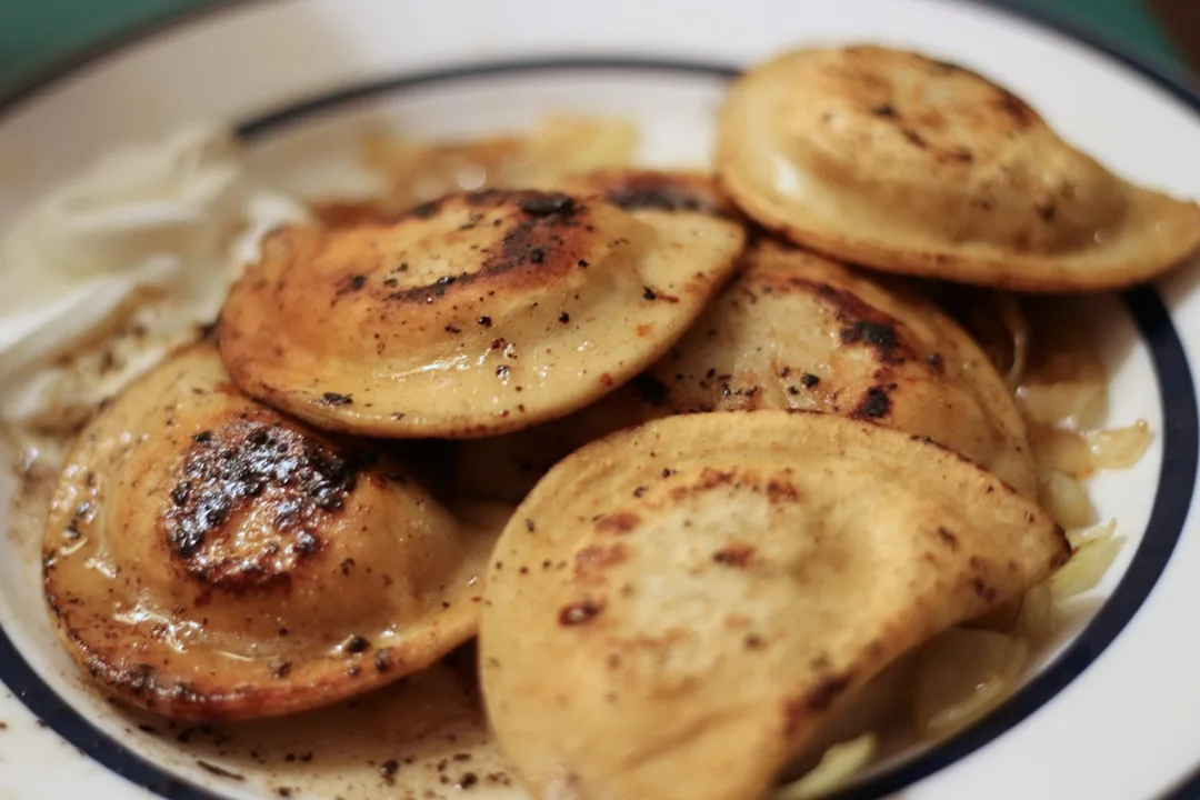 a white plate topped with potatoes and gravy