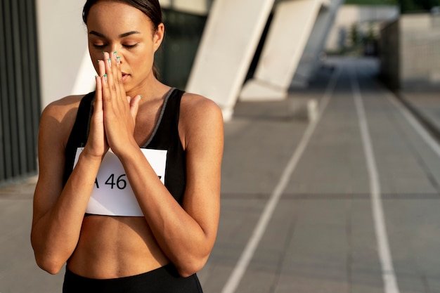 Medium shot woman praying outdoors
