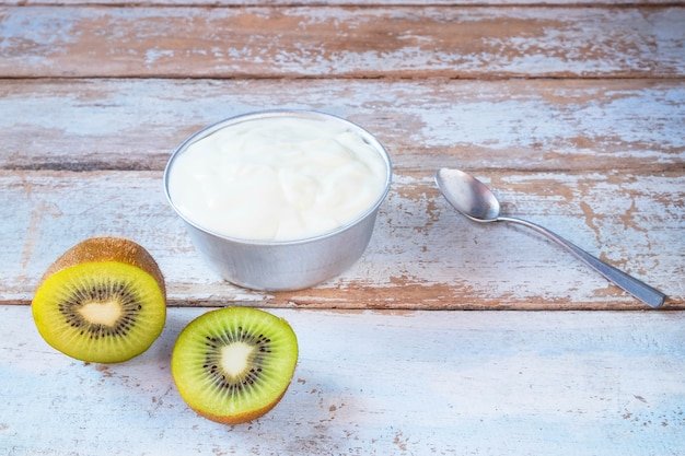 Natural yogurt and kiwi fruit on wooden table