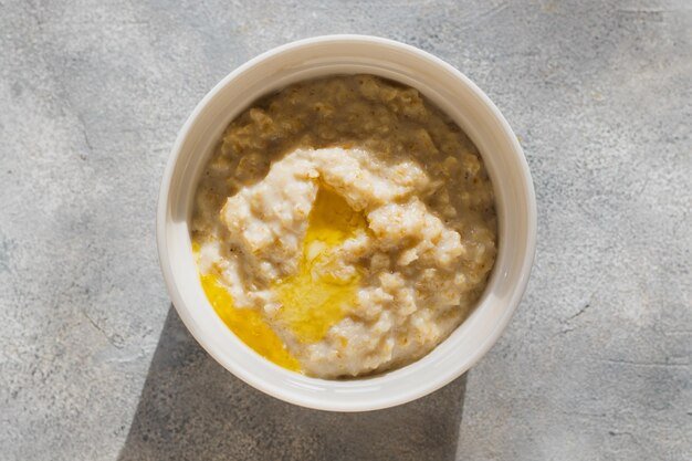 Oatmeal porridge with butter on grey background Healthy eating dieting fitness food natural light