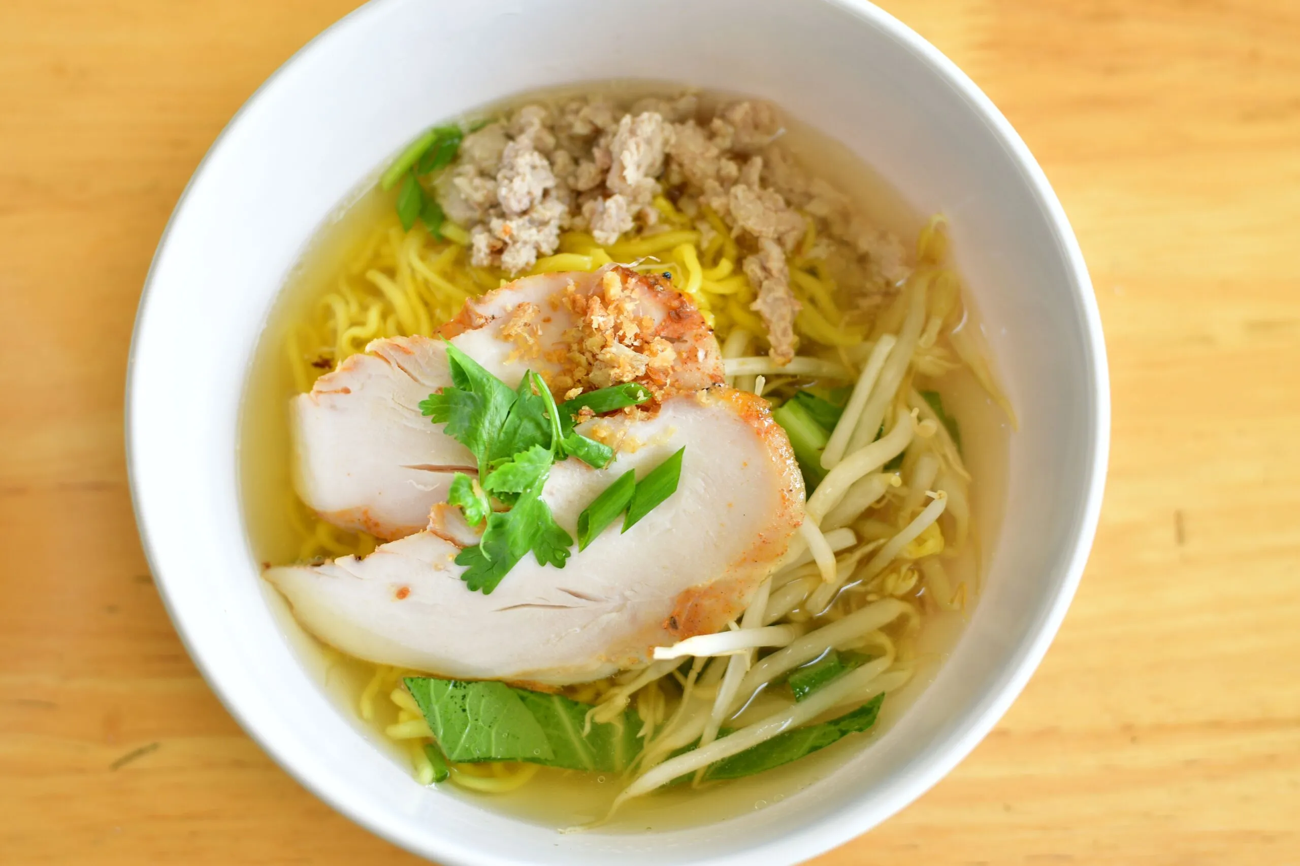 Savor a bowl of chicken noodle soup with fresh herbs, perfect for comfort and flavor.