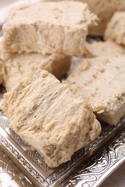 Pieces of tasty halva served on tray closeup