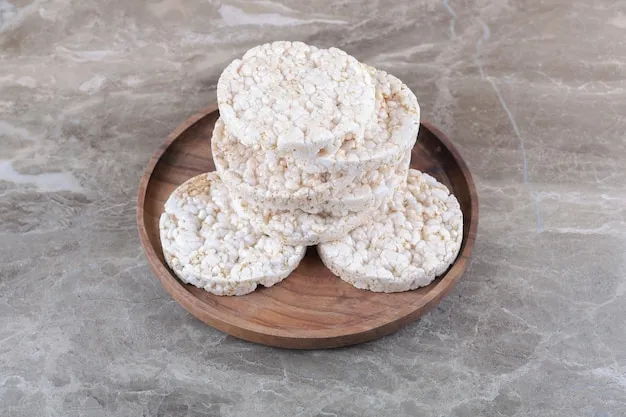 A pile of puffed rice cakes on the wooden tray, on the marble background.