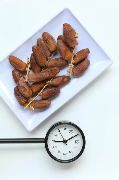 A plate of dates for breakfasting and a clock on 0555 PM Ramadan breakfasting concept