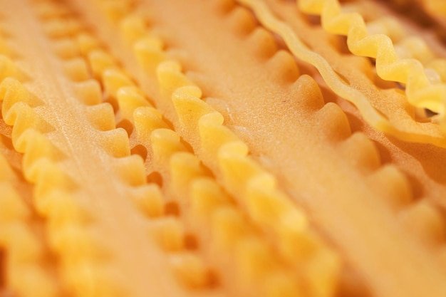 Raw italian pasta called mafaldine  flat and wide pasta with wavy edges   abstract effect