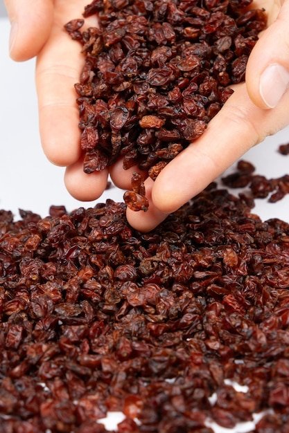Red dried barberry natural seasoning pouring out of human hands