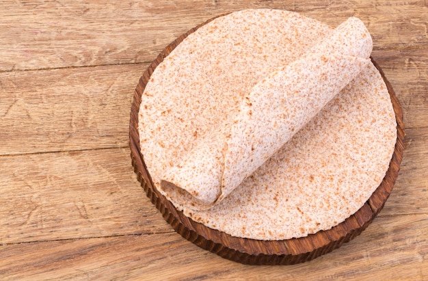 Stack of homemade whole wheat flour tortilla  on wooden table background
