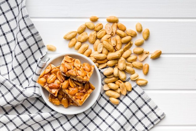 Sweet peanut brittle Tasty peanuts in caramel on the checkered napkin Top view